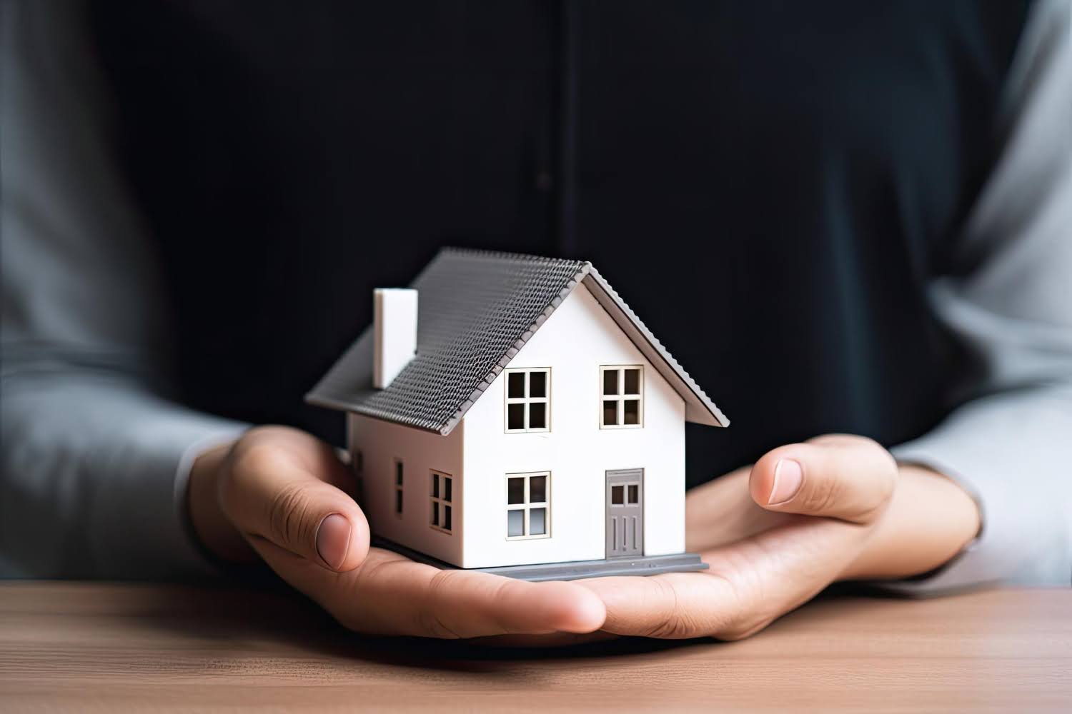 person holding house model in hands nwls