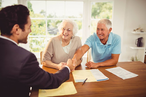 lawyer shaking hands with elderly couple ssi benefits assistance northwestern pennsylvania northwestern legal services 